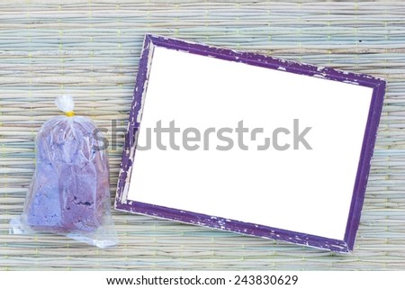 wooden old black picture frame on traditional mat with white space in the middle with shrimp paste in plastic bag