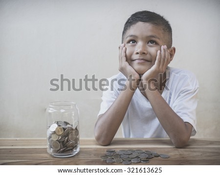 Young boy counting his saved coins and thinking about what he can buy