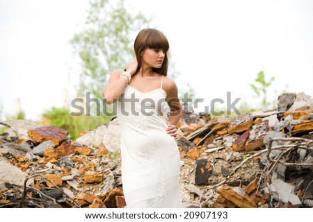 fashionable girl in white dress on the dirty industrial place