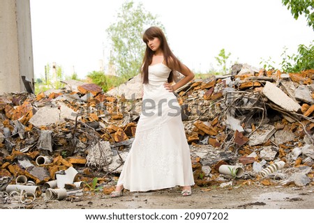 fashionable girl in white dress on the dirty industrial place