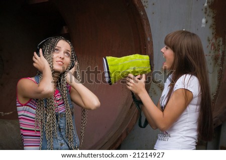 girl singing in megaphone for another girl who listing music in headphones