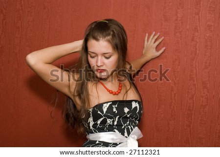 young pin-up girl in front of red wallpaper