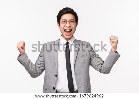 Waist-up portrait of pleased, successful asian businessman got his first deal, feeling like champion, fist pump empowered, shouting yes satisfied, triumphing and celebrating victory, white background ストックフォト © 