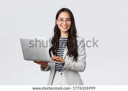 Business, finance and employment, female successful entrepreneurs concept. Confident smiling asian businesswoman, office worker in white suit and glasses using laptop, help clients