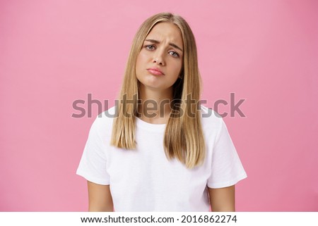 Sad girl whining tilting head raising eyebrows in upset expression and pursing lips feeling disappointed and envy, regretting missed chance standing unhappy and moody over pink background Сток-фото © 