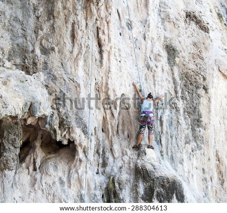 RAILAY, THAILAND - JUNE 10, 2014: Rock climbers climbing the wall on Railay beach, one of the best rock climbing in Asia.