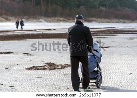 Man walking with stroller near sea beach in Latvia