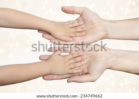 father and son holding hands on christmas lights background