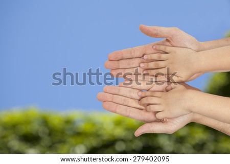 father and son holding hands on natural green background
