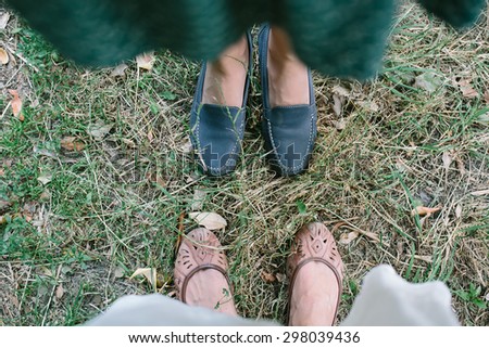 Best friends feet standing on the grass outdoors