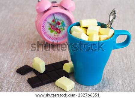 Hot chocolate  in the blue cup with pink alarm clock