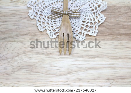 picture of fork, doily with wood background