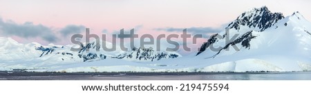 A panoramic picture of the sunset over snow mountains in Antarctica.