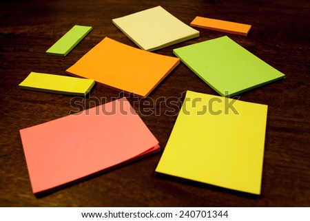 Colorful blank notes lying on a table. Sticky notes in various shapes and colors.