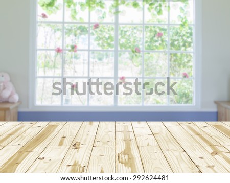 Wood table top on window interior room blurry background.