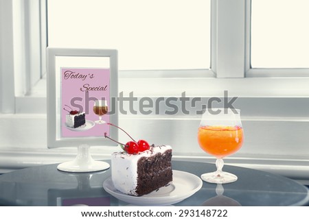 Cherry chocolate cake and Orange juice setting on table.  Soft focus on cherry