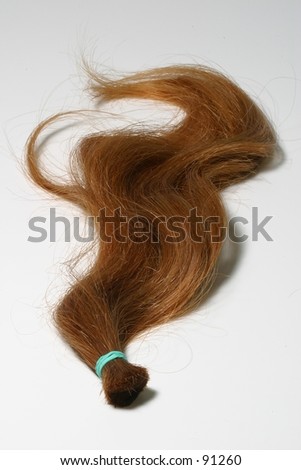 A lock of natural red hair against a white backdrop.  This could symbolize love, or the Irish.