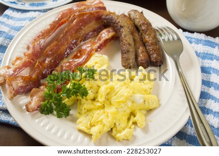 large hot breakfast with scrambled eggs and bacon with sausage 