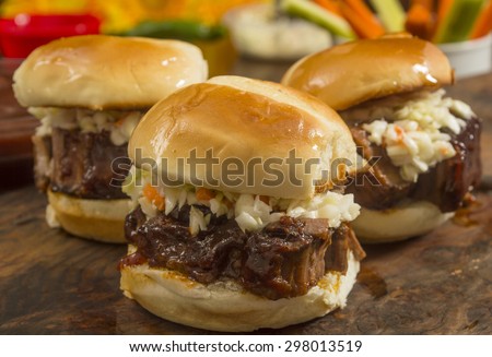 beef brisket sliders smothered in BBQ sauce and topped with cole slaw ready to eat\