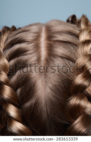 Close-up blonde head with pigtails on blue background