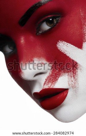 Beautiful female model with white skin, red lips and blood on face. Halloween makeup.