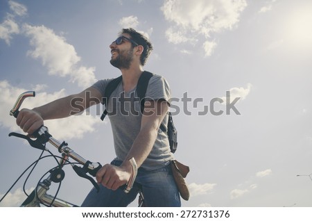 Man riding a bicycle in nature in retro style.