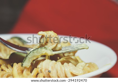 wheat pasta with zucchini and fork in white dish/Wheat pasta with zucchini