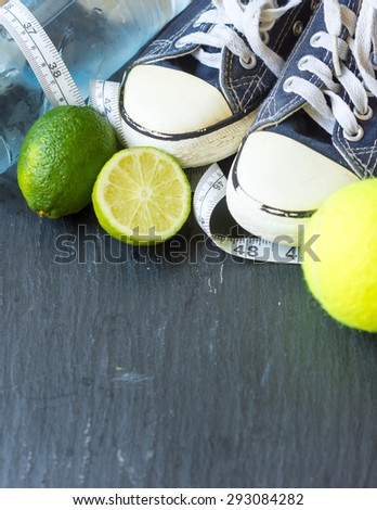 Sport shoes,  lime,tennis ball  and water on black background