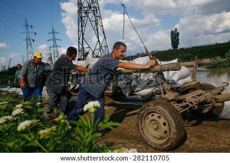Galati, Romania - June 29, 2010: Workers push a wagon full of sandbags to stop a flooding