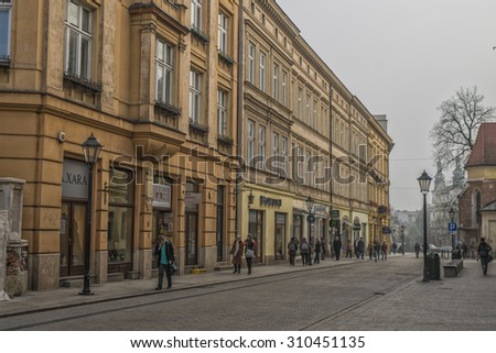 KRAKOW, POLAND - OCT 30, 2014: Walking tourists towards the center of the old town. The architecture the ancient town. Picture taken in the evening during a trip to Krakow.