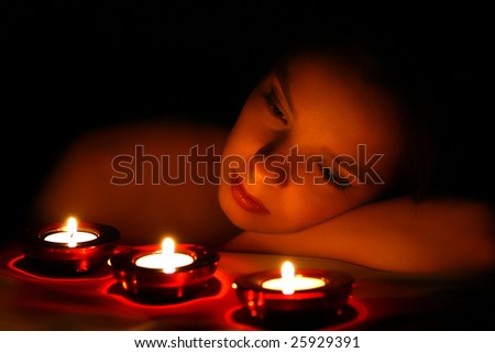 Woman looking on three candles