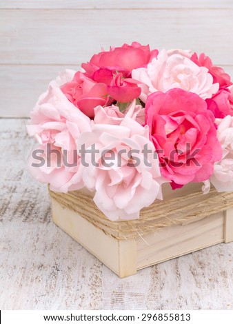 Pink and pale pink roses bouquet in the wooden box tied with jute rope