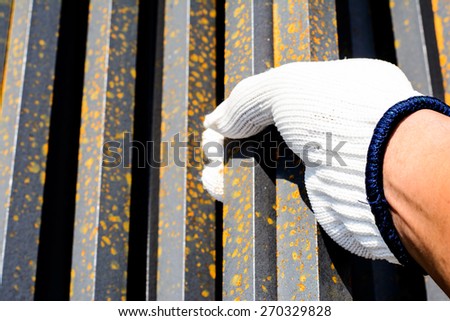 Safety a hand by white glove for working time of labor,workman with bundle bars,iron ready for construction.Focus on a white glove
