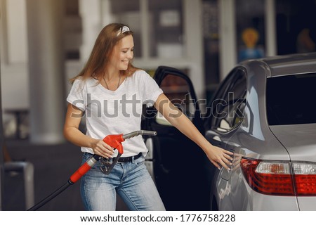 Woman on a gas station. Lady in a white t-shirt. Woman near the car. Stock fotó © 