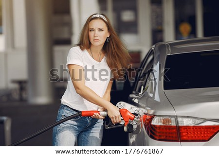 Woman on a gas station. Lady in a white t-shirt. Woman near the car. Stock fotó © 