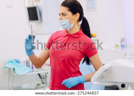 Two professional doctors treat teeth beautiful woman