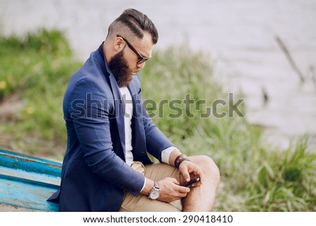 bearded man on the boat with phone