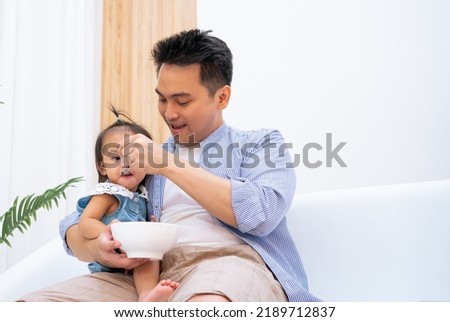 Similar – Image, Stock Photo Single dad feeding his baby who is sat in a high chair