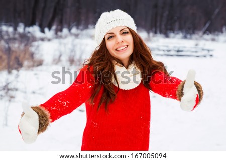 Pretty yong woman in red sweater outdoors