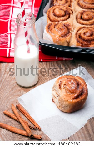 Milk in a bottle with paper straw and delicious  cinnamon bun