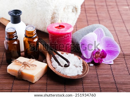 Spa still life with vanilla pods, hand made soap, aroma oils and pink orchid flower