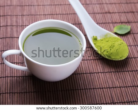 Matcha tea in a white cup on the mat, close-up