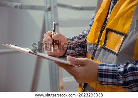 building contractor Check and write down the details of the construction. wearing yellow construction clothes house construction contractor concept 商業照片 © 