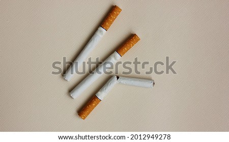 Similar – Image, Stock Photo Two cigarettes from above laying flat on pink and purple backgrounds as a symbol of female smoking