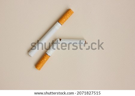 Similar – Image, Stock Photo Two cigarettes from above laying flat on pink and purple backgrounds as a symbol of female smoking