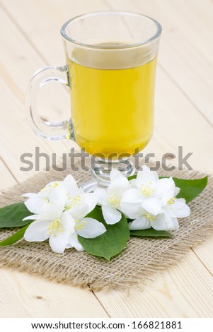 glass of jasmine tea and jasmine flowers