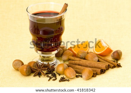 glass of hot wine with orange, nuts and spices