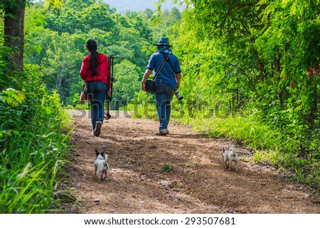photographer- walking into the Woods to shoot nature and insects that are Dam slow water. Village of Mae Tha, Lampang ,Thailand that continue to preserve nature, remain long-July 4 2015.