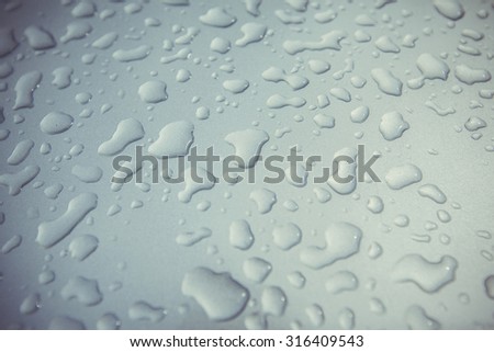 Water (rain) drops on silver metal surface of the car closeup