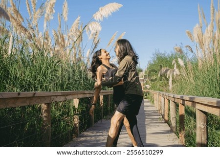 Similar – Image, Stock Photo Couple embracing on bridge under arch with flowers